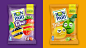 two bags of fruit and vegetables on purple and orange background, one with an emoticive face