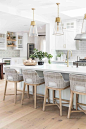 Love everything about this bright white kitchen.  The counter stools are perfect with the wood base and the brass and glass pendants balance out the space #whitekitchen #kitchendesign