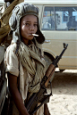A child soldier poses with helmet, cigarette and a Russian AK-47 rifle Kalashnikov Kalait April 1987, after the defeat of the Libyan army during the conflict between Libya and Chad.: