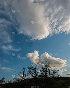 白色的云在黑暗的森林背景和傍晚的天空在农村。