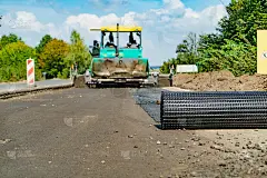 专业设备在公路上的砂砾和加固网边睡着了。