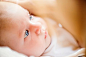 Little baby boy lying in wooden crib, close up