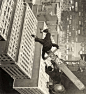 A man balancing on a piece of wood on the roof of a skyscraper 1939