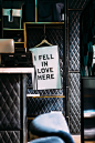 Sign on a hanger in luxurious environment reads, "I fell in love here."