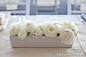 宴会桌上摆放着一片白色花卉，既有真花也有纸花