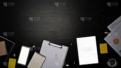 俯视图智能手机，数码平板电脑，剪贴板和金融文件在黑色的桌子。
