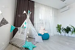 儿童帐篷在婴儿房壁纸背景。当代学前游戏室儿童玩具装饰幼儿园家具元素。舒适的孩子气的棚屋安排现代公寓