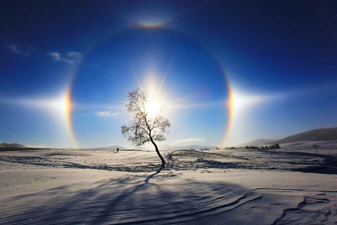 日晕与多日同辉:大气中冰晶反射太阳光,以太阳为中心形成彩色光环叫日