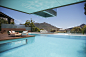 Woman sunbathing on lounge chair at poolside with mountain view by Caia Images on 500px