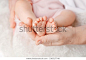 婴儿脚在母亲手中。 微小的新生儿宝宝的脚在女性形状的手特写. 妈妈和她的孩子。 幸福的家庭概念。 美丽的概念形象的孕妇