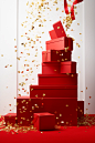 Red box with gold confetti and confetti coming down steps, in the style of indoor still life, simplified compositions, wrapped, piles/stacks, crisp and clean, commercial imagery, spiral group