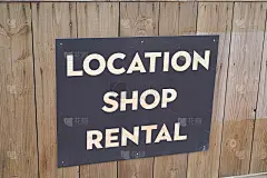 店面位置商铺出租文字招牌在店面背景木墙上