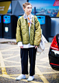 Jenny Walton wears a white shirt, quilted army jacket, floral scarf, cropped pants, and sneakers