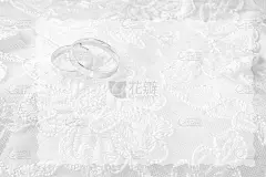结婚戒指在结婚卡片上，白色的婚纱上