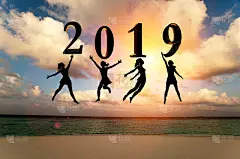 2019年新年贺卡。剪影年轻女子跳在热带海滩上的海洋和2019年数字日落的背景。