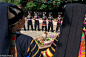 Red Yi women circling a sacrificial cow's head offering during a festival in the village of Powu.