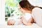 Caucasian mother playing with baby on changing table by Gable Denims on 500px