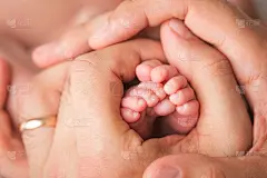 慈爱的父母扶着宝宝的腿。快乐的童年。父母的关心。