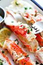 Easy baked crab legs in oven with lemon garlic butter sauce, with a fork.