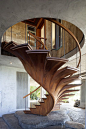 A long set of African mahogany and teak stairs designed by a woodworking craftsman to look like a curved philodendron plant.: 