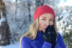 漂亮女人对着戴着手套的手吹气