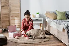 点击来源直接获取大图文件 |preteen girl sitting on floor and playing with toy tea set and cat.