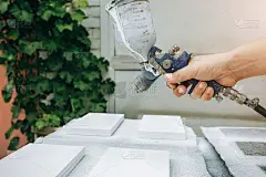 人拿着喷枪喷雾器进行绘画和染色。工人维修房屋或公寓。