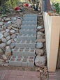 good base for a sloped walkway then put prettier stones on top to hide the practical cinder blocks: 