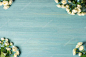 Top view of Mother's day holiday composition with beautiful white roses in corners on blue wooden background