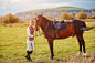一个美丽的女孩的肖像穿着经典的运动服骑手和她的马