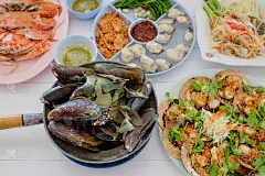泰式海鲜(炸鱼，蟹肉炒饭，蟹子沙拉，木瓜沙拉，虾，香草烤贻贝)，白色背景。方的概念。