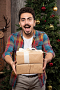 Free photo smiling handsome man carrying christmas gifts.