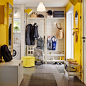 A bright yellow and white mudroom with a white coat and shoe rack.