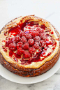 Fresh raspberry cheesecake with white chocolate, topped with raspberry sauce and fresh raspberries.