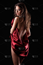 深色背景上穿红色丝绸衣服的女人