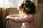 girl holding white pearl necklace inside room