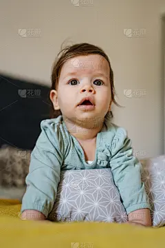 正面看到快乐的小白种人宝宝白天躺在家里的床上