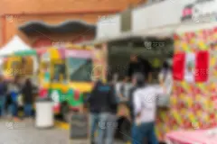 在一个阳光明媚的日子里，人们在街头食品市场上庆祝。故意模糊。