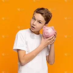 一个十几岁的男孩摇晃着他的存钱罐，试图猜出钱的数字