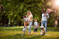 Young happy parents talking to their kids while enjoying a day in nature.