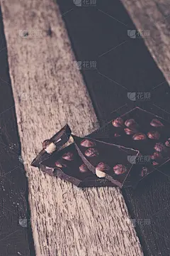 巧克力块和榛子坚果在木背景。健美的照片。
