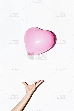 粉红色的心形气球悬浮在白色的空中