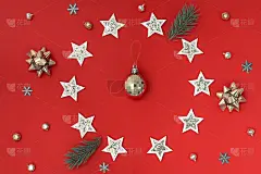 用白色、金色和冷杉树枝在红色背景上装饰的圣诞装饰品。