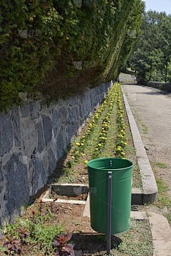 垃圾桶在公园里，花坛旁边