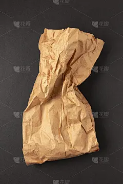 棕色皱巴巴的纸袋，背景是黑色的