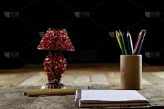 在旧桌子上的素描簿和旧的感官台灯。黑色背景