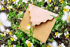 在自然的地面上制作黄花绿叶的信封模型。平的。树叶的俯视图。自然的概念。婚礼邀请函模板。春天自然壁纸