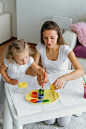 Mother and toddler child painting at home creative family