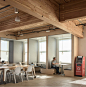 Oficinas para Simple / Hacker Architects | Dis-Up! : Una paleta de materiales mínima enfatiza la estructura de madera del edificio mientras la iluminación, los muebles y las alfombras se seleccionaron para crear un ambiente informal