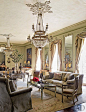 Renovating a French-Inspired Houston MansionLiving Room The ballroom turned living room includes custom-made club chairs covered in a Clarence House velvet, a pair of Empire fauteuils, a mirrored cocktail table by Ellouise Abbott, and a 19th-century writi